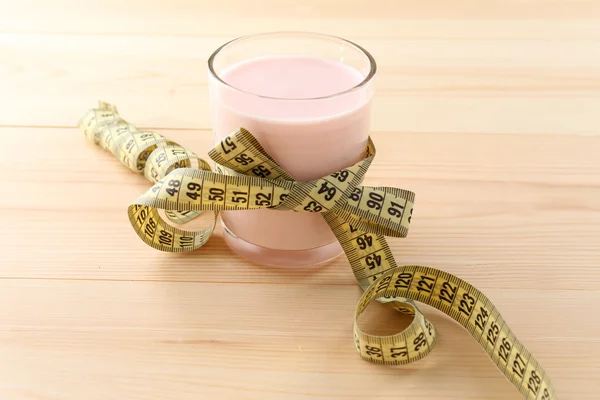 Glass of dietary cocktail with measuring tape on wooden table background — Stock Photo, Image