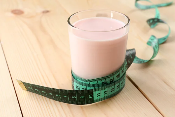 Glass of dietary cocktail with measuring tape on wooden table background — Stock Photo, Image