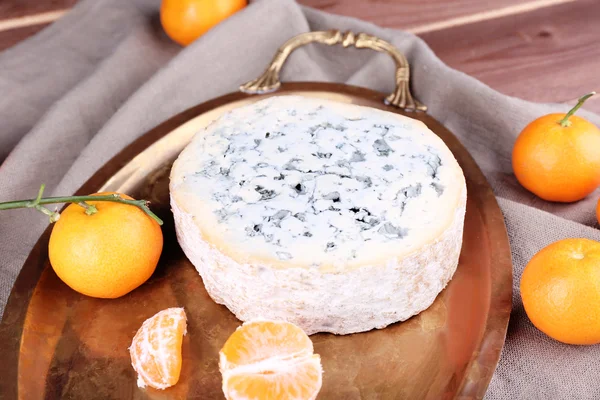 Blauwe kaas met sinaasappelen op metalen lade op jute doek en houten tafel achtergrond — Stockfoto