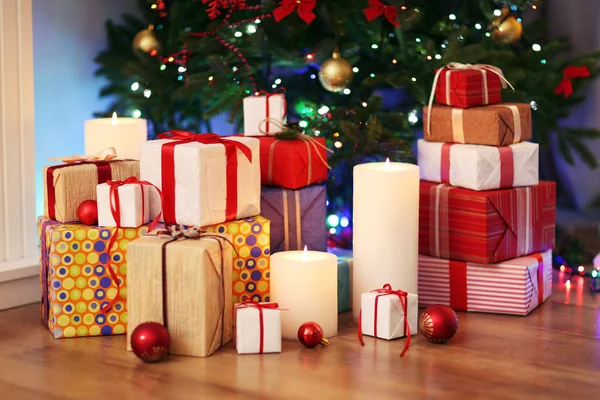 Montón de cajas de regalo bajo el árbol de Navidad en el suelo de madera, en el interior — Foto de Stock