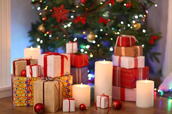 Stapel van huidige vakken onder kerstboom op houten vloer, binnenshuis — Stockfoto