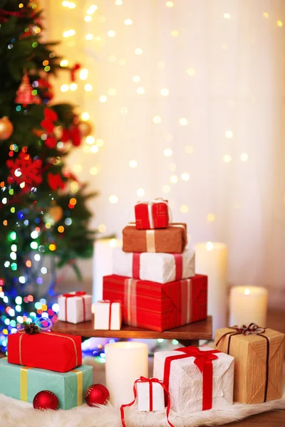 Montón de cajas de regalo de Navidad en la alfombra de piel en el suelo de madera, sobre fondo brillante —  Fotos de Stock