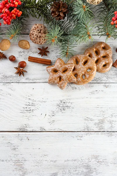 Soubory cookie s kořením, jeřáb a vánoční borovice větvičky na barevné dřevěné pozadí — Stock fotografie