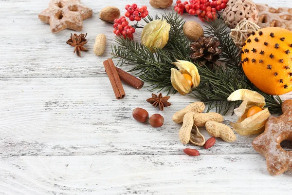 Orange avec épices, rowan et branche de pin de Noël sur fond de bois de couleur — Photo