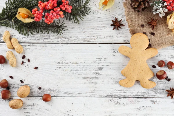 Christmas pine sprig with spices and gingerbread on color wooden background — Stock Photo, Image