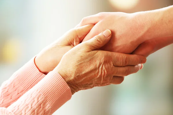 Old and young holding hands — Stock Photo, Image