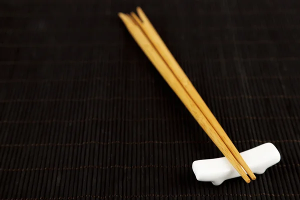 Pair of chopsticks on black bamboo mat background — Stock Photo, Image