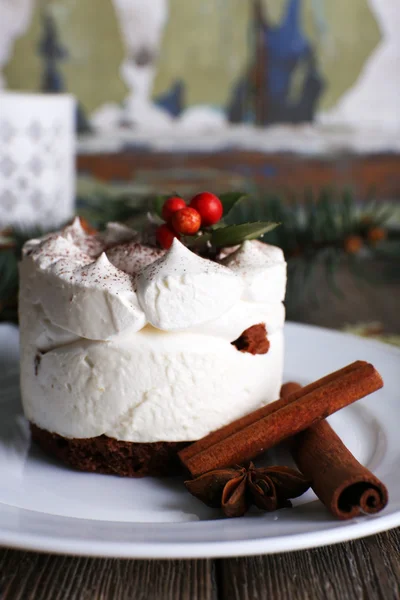 Delicioso pastel en plato con canela y anís estrellado en el fondo de la decoración de Navidad — Foto de Stock