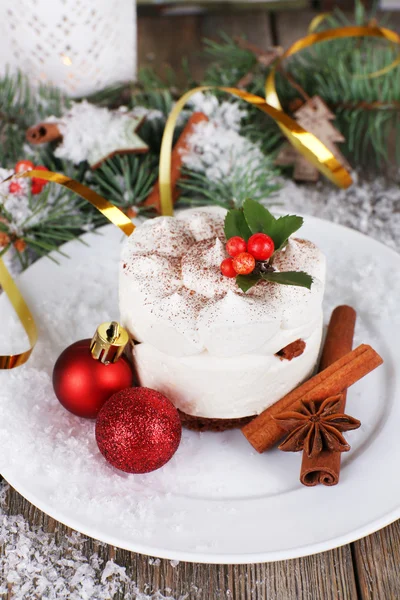 Delicious cake on plate with cinnamon and star anise on Christmas decoration background — Stock Photo, Image