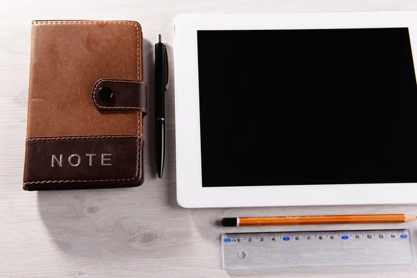 Tablet PC con cuaderno sobre fondo de mesa de madera — Foto de Stock