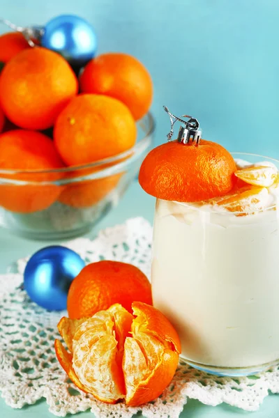 Sabroso postre de leche con trozos de mandarina fresca en tazón de vidrio, sobre fondo de madera de color —  Fotos de Stock