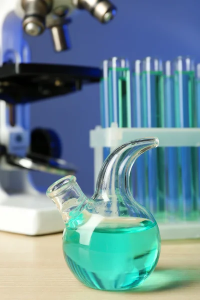 Microscope and test tubes on table, on color background — Stock Photo, Image