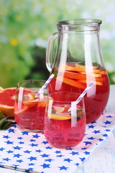 Gözlük ve sürahi doğal zemin üzerine masada pembe limonata — Stok fotoğraf