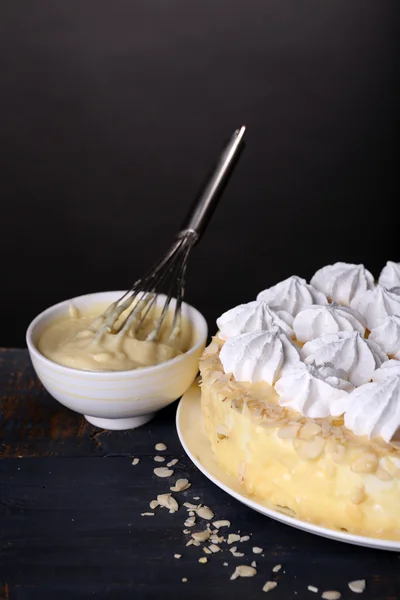 Bolo de merengue caseiro saboroso na mesa de madeira, no fundo cinza — Fotografia de Stock