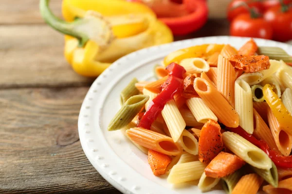 Ensalada de pasta con pimienta, zanahoria y tomates sobre fondo de mesa de madera —  Fotos de Stock