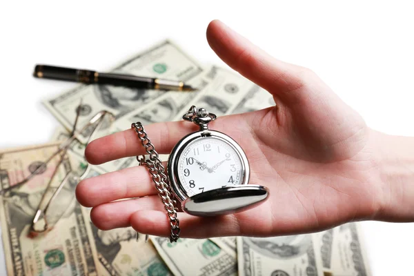 Silver pocket clock in hand on money background. Time is money concept — Stock Photo, Image