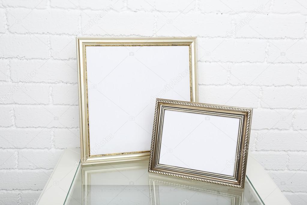 Photo frames on coffee table on brick wall background