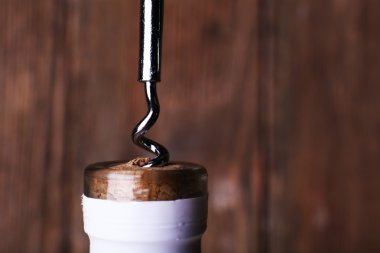 Şişe açacağı yakın plan, ahşap arka planda.