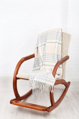 Ekose tuğla duvar arka plan yakınındaki ahşap zemin üzerinde sallanan sandalye kaplı