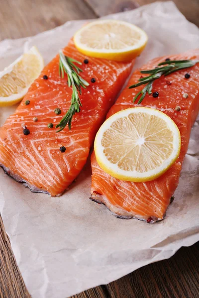 Salmón fresco con especias y limón sobre mesa de madera —  Fotos de Stock