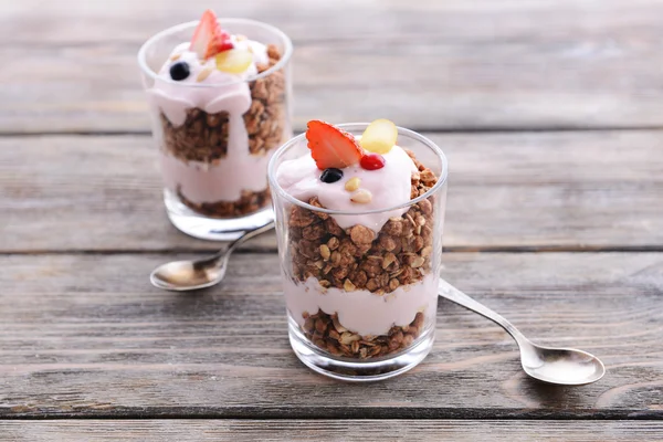 Postre en capas saludables con muesli y bayas en la mesa —  Fotos de Stock