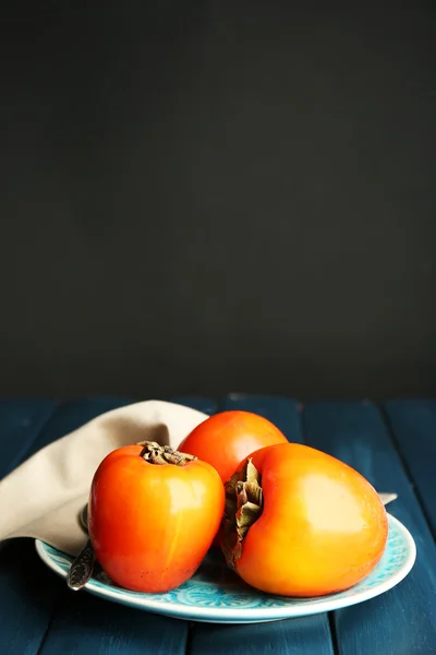 Ripe sweet persimmons, on wooden table — Stock Photo, Image