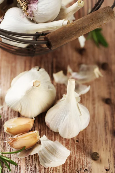 Rauwe knoflook en kruiden op houten tafel — Stockfoto