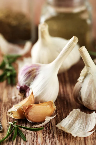 Rauwe knoflook en kruiden op houten tafel — Stockfoto