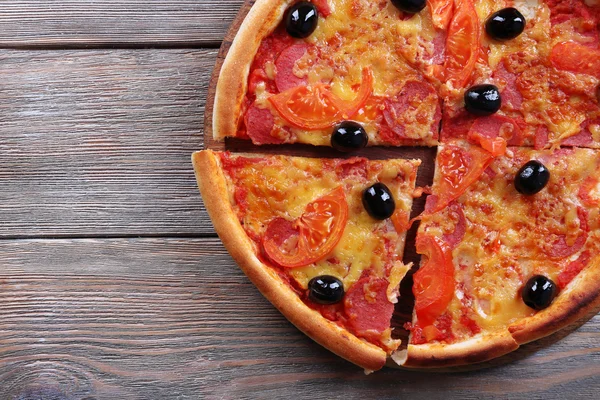 Pyszne pizza włoska z czarnymi oliwkami na drewnianym stole tło — Zdjęcie stockowe