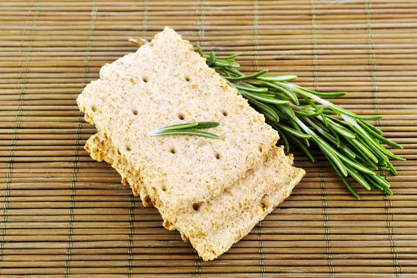 Knäckebrot mit Rosmarinzweigen auf Bambusmatte Hintergrund — Stockfoto