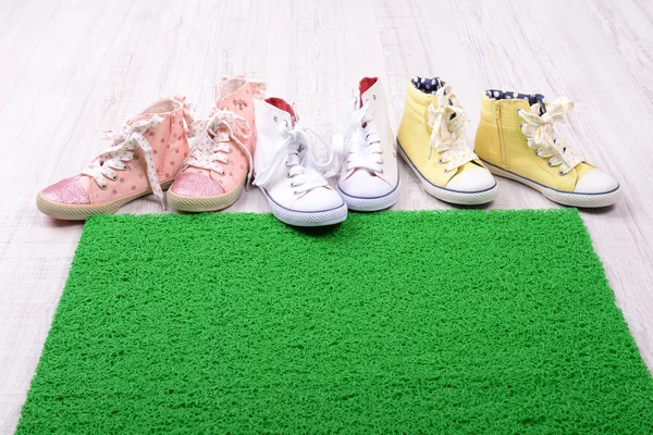 Green carpet on floor and converse close-up — Stock Photo, Image