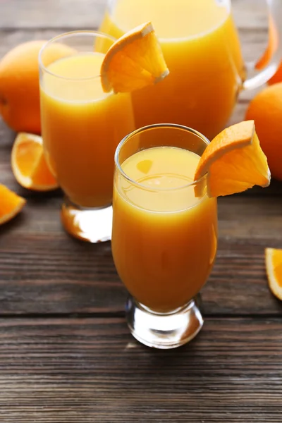Čerstvě vymačkaná pomerančová šťáva na dřevěný stůl — Stock fotografie