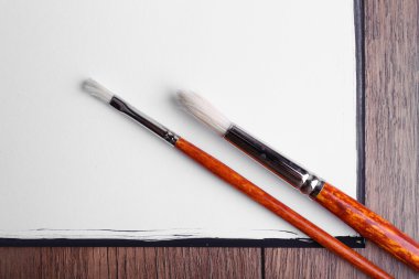 Boş kağıt ahşap masa arka plan üzerinde fırça ile sayfası