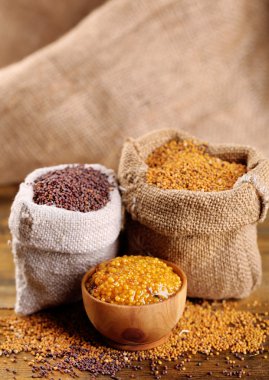 Çanta ve ahşap arka plan üzerinde kasede sos hardal tohumu