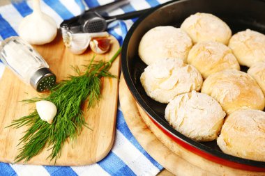 Taze ev yapımı ekmek buns hamur mayaları pan ve taze sarımsak, dereotu renk peçete arka plan üzerinde kesme tahtası üzerinde