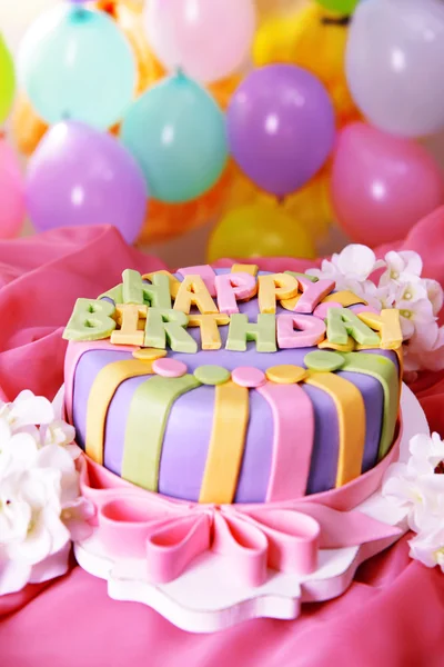Delicioso bolo de aniversário na mesa no fundo brilhante — Fotografia de Stock