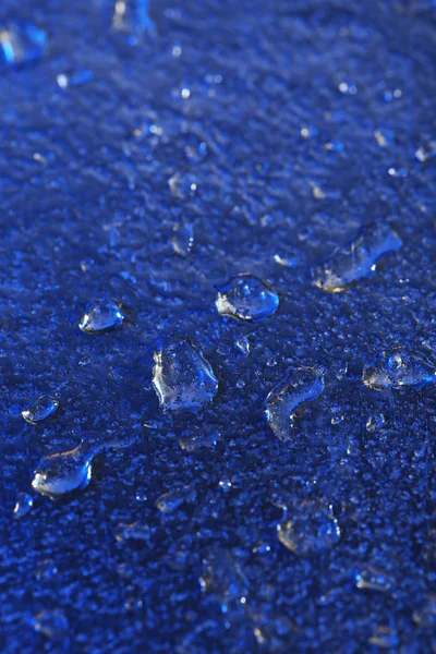 Gotas de agua sobre fondo de superficie de color, vista macro —  Fotos de Stock