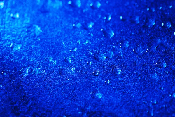 Gotas de agua sobre fondo de superficie de color, vista macro — Foto de Stock