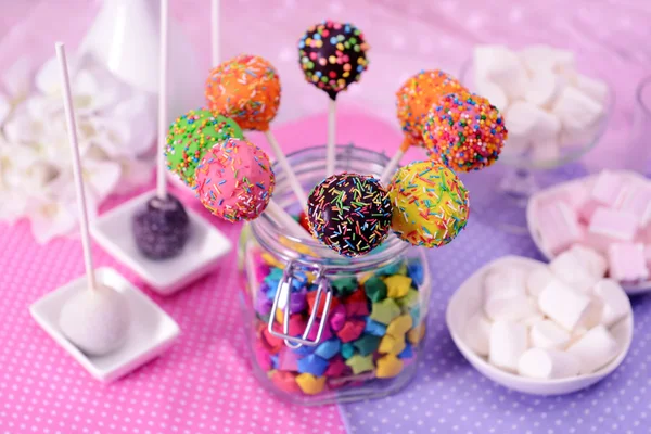 Sweet cake pops in jar on table on bright background — Stock Photo, Image