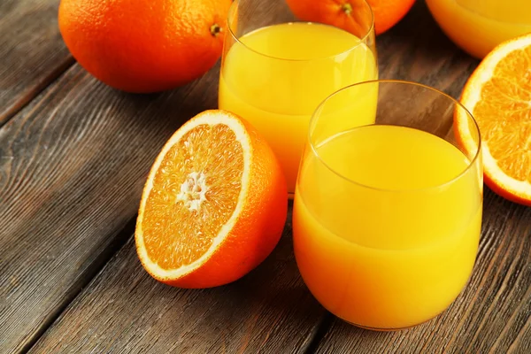 Copo de suco de laranja com fatias no fundo da mesa de madeira rústica — Fotografia de Stock