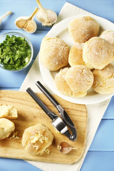 Čerstvý domácí chléb buchty z kynutého těsta na dřevěné prkénko, na barevné dřevěné pozadí — Stock fotografie