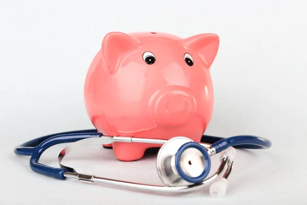 Pink piggy bank with stethoscope isolated on white — Stock Photo, Image