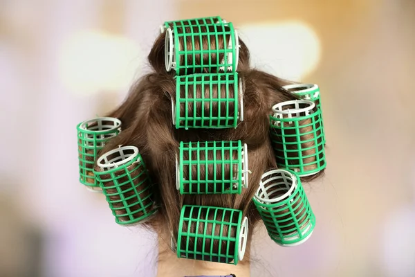 Lunghi capelli femminili durante il parrucchiere con bigodino, primo piano, su sfondo chiaro — Foto Stock