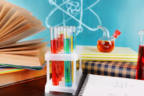 Glassware with chemical agent on desk, on green blackboard background — Stock Photo, Image