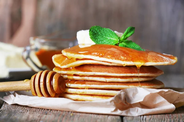 Stack of pancakes with honey and butter on rustic wooden background — Stock Photo, Image