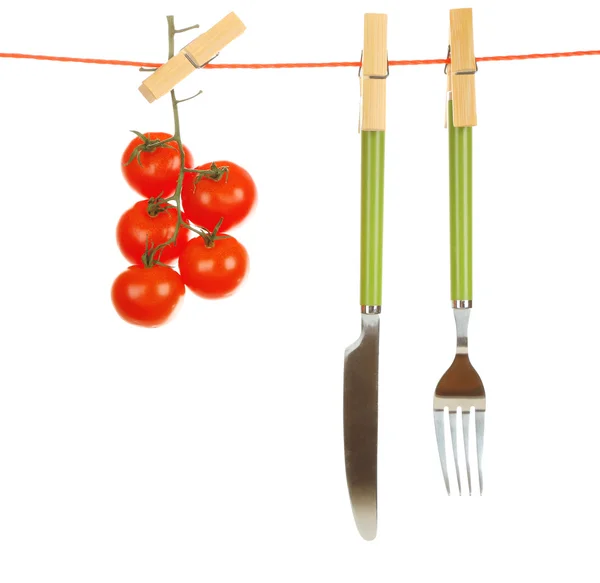 Fork, knife and ripe red tomatoes hanging from clothesline isolated on white background — Stock Photo, Image