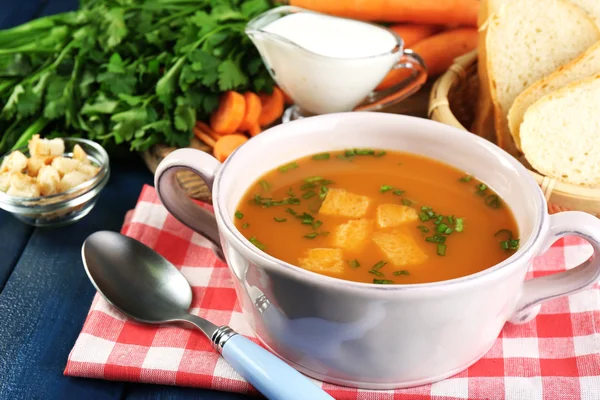 Composition with carrot soup, ingredients and herbs on color wooden background — Stock Photo, Image