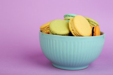 Yumuşak renkli macaroons renk arka plan üzerinde renkli kase çeşitleri