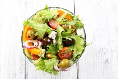 Cam tabak renk ahşap masa arka plan üzerinde Yunan salatası