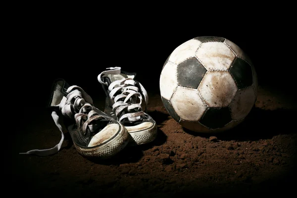 Soccer ball on ground on dark background — Stock Photo, Image